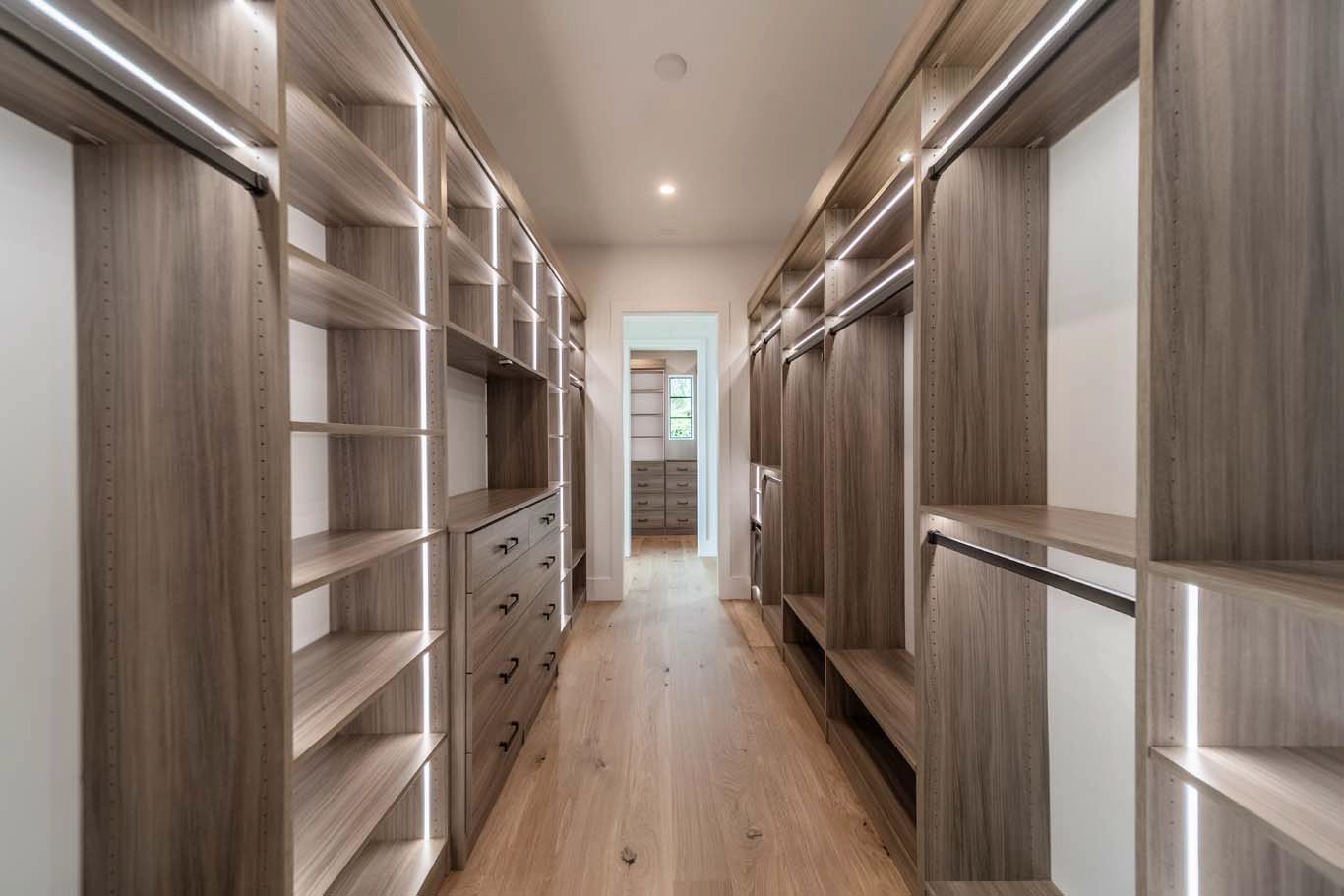 Walk-in closet with LED lighting and wood-grain cabinetry
